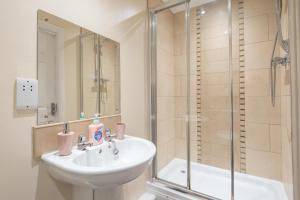 ein Bad mit einem Waschbecken und einer Dusche in der Unterkunft Apartment 8 in Worksop