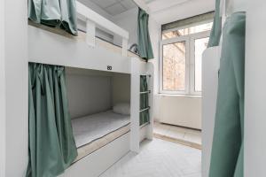 リヴィウにあるIn Town hostelの二段ベッド1組、窓が備わる小さな客室です。