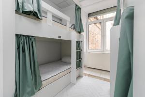 a small room with a bunk bed and a window at In Town hostel in Lviv