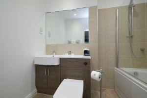 a bathroom with a toilet and a sink and a shower at Last Drop Village Hotel & Spa in Bolton