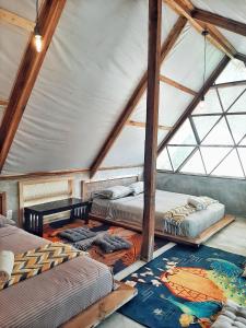 een kamer met 3 bedden op een zolder bij Cabanas de Nacpan Camping Resort in El Nido