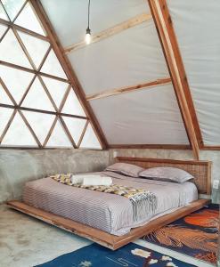 Cama en habitación con marco de madera en Cabanas de Nacpan Camping Resort en El Nido