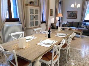 a dining room with a wooden table and white chairs at Romantic Rialto in Venice