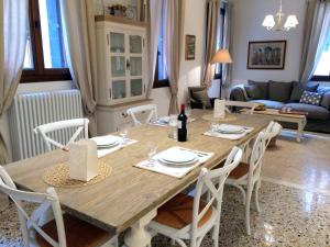 comedor con mesa de madera y sillas blancas en Romantic Rialto, en Venecia
