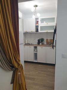 an open door to a kitchen with white cabinets at Studio Sofia in Râmnicu Vâlcea
