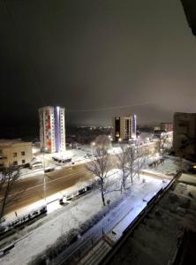 a city at night with snow on the ground and buildings at 1 комнатная квартира in Uralsk +3 photos