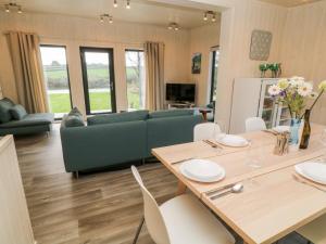 a living room with a couch and a table and chairs at Dragonfly Lodge in Bideford
