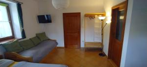 ein Wohnzimmer mit einem Sofa und einem TV in der Unterkunft Apartments Anna in Černý Důl