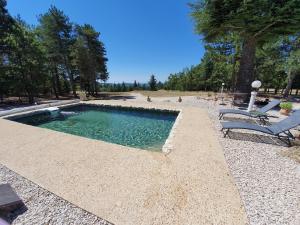 a swimming pool with a bench and a chair at Gîte Le Refuge in Monieux +13 photos