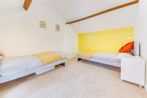 1 dormitorio con 2 camas y pared amarilla en Unique & Cosy Coach House - Sheffield Chantrey Road en Heeley