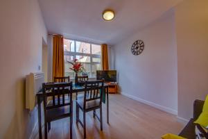 a dining room with a table and chairs and a clock at Unique & Cosy Coach House - Sheffield Chantrey Road in Heeley