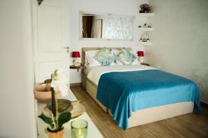 a bedroom with a bed with a blue blanket at Studio Sofia in Râmnicu Vâlcea