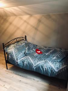 a bed with a blue comforter with a red object on it at Cozy Apartment Fremersberg for 2 in Baden-Baden