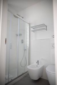 a white bathroom with a shower and a sink at Hotel Ligure in Spotorno