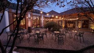 a group of tables and chairs in front of a building at Pinares Panorama Suites & Spa in Villa Carlos Paz