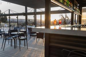 a restaurant with a bar with chairs and tables at Pinares Panorama Suites & Spa in Villa Carlos Paz