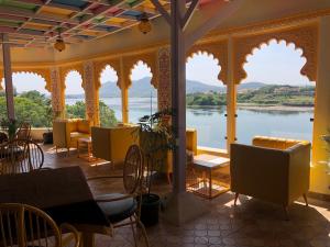 a restaurant with a view of the water at Haveli BALAVH with lake facing balcony in Udaipur