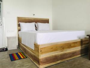 a large bed with a wooden frame in a room at fantasea villa in Unawatuna