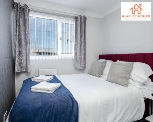 a bedroom with a large bed with towels on it at Spacious 3 bedroom house with wifi and car parking By Hinkley Homes Short Lets & Serviced Accommodation in Waterloo