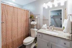 a bathroom with a toilet and a sink and a mirror at The Sanctuary Company Johnson City in Johnson City +19 photos