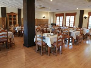 a dining room with tables and chairs with white table cloth at Hotel Rural Villa de Vinuesa in Vinuesa +24 photos