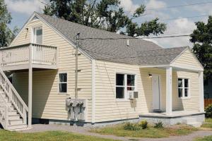 a small white house with a porch and stairs at Charming Apt with chic decor Superhost w 5 Stars in Bristol