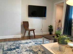 a living room with a chair and a tv on the wall at The Rustic Retreat- close to downtown in Bristol