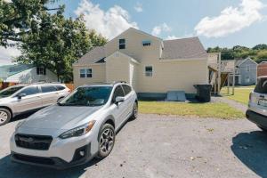 a white car parked in front of a house at The Rustic Retreat- close to downtown in Bristol