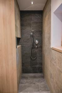 a bathroom with a shower with a glass door at Brünnl's Försterhütte in Parcines