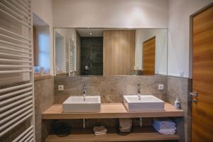 a bathroom with two sinks and a large mirror at Brünnl's Försterhütte in Parcines