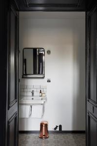 a bathroom with a mirror and a sink and towels at Le Boutik Hotel in Annecy