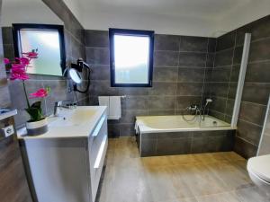 a bathroom with a sink and a tub and a toilet at Hôtel Casa Mea in Bastia