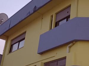 un edificio amarillo con techo azul en Giovanna 199, en Rende