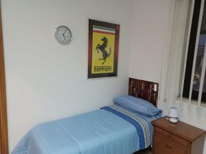 1 dormitorio con 1 cama y reloj en la pared en Giovanna 199, en Rende