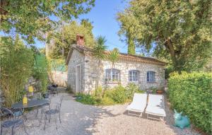 ein Steinhaus mit einer Terrasse, einem Tisch und Stühlen in der Unterkunft Beautiful Home In La Gaude With Kitchen in La Gaude