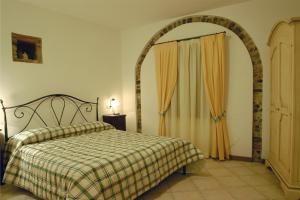 a bedroom with a bed with a plaid blanket and a window at Casale di Pegol in Tignale