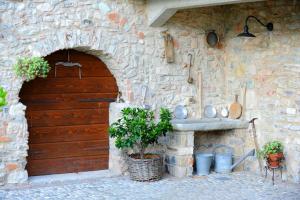 ein Steingebäude mit einer Holztür und einem Waschbecken in der Unterkunft Casale di Pegol in Tignale