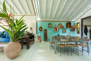 un comedor con una mesa y un jarrón con una planta en UXUA Alma, en Trancoso