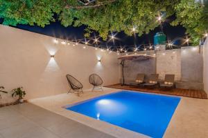 a pool in a patio with chairs and a table at Youssef Exceptionnel Merida in Mérida