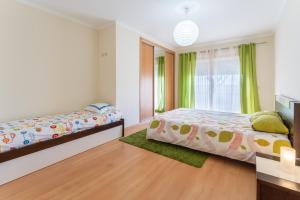 1 dormitorio con 2 camas y ventana en Apartamento T3 Beira Mar, en Nazaré