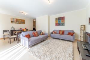 uma sala de estar com dois sofás e uma mesa em Apartamento T3 Beira Mar na Nazaré