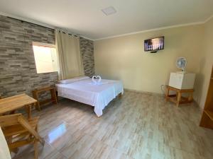 een kamer met een bed, een tafel en een ventilator bij RDS Hospedagem in Itacaré