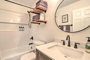 ein weißes Badezimmer mit Waschbecken und Spiegel in der Unterkunft Cottage with Grill and Fire Pit in Osage Beach! in Osage Beach + 16 Fotos