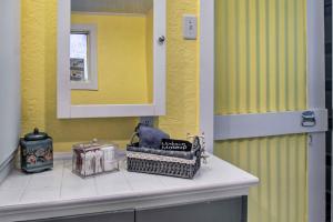um banheiro com paredes amarelas e um balcão com itens nele em Colorful Bisbee Home with Patio about 1 Mi to Dtwn! em Bisbee mais 27 fotografias
