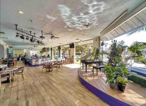 a large room with tables and chairs and plants at Pink Sunsets at the Palms of Destin Across from Beach, Heated Pool Shuttle & Dining in Destin