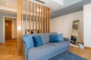 uma sala de estar com um sofá cinzento e almofadas azuis em Magic Home 57 em Turim