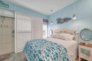 Picturesque Waterfront Studio في كليرووتر بيتش: غرفة نوم بجدران زرقاء وسرير وباب