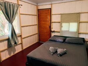 a bedroom with a bed with two pillows and a window at LONELY GROOVE in Ko Chang +68 photos