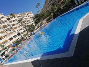 una gran piscina frente a algunos edificios en BOUTIQUE Apartment, en Los Cristianos