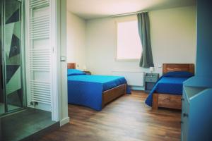 a bedroom with two beds and a window at FORESTERIA LOMBARDA BED and BIKE CREMONA 